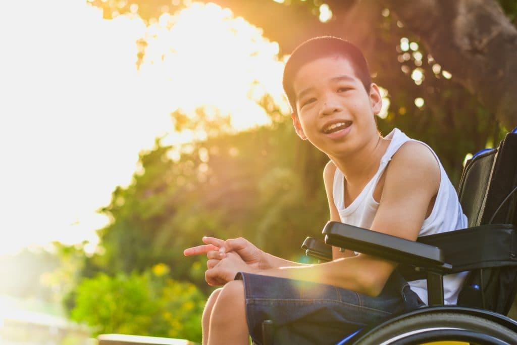 Jeune adolescent souriant en fauteuil roulant — accompagnement handicap ARTEMIS à Carpentras